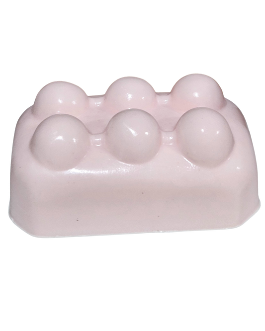 Pink soap bar with spherical lumps on a white background.“Pink Lemonade Mint Massage Soap Bar by Shea Butter Heaven – 4 oz exfoliating handmade soap
