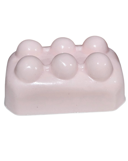 Pink soap bar with spherical lumps on a white background.“Pink Lemonade Mint Massage Soap Bar by Shea Butter Heaven – 4 oz exfoliating handmade soap