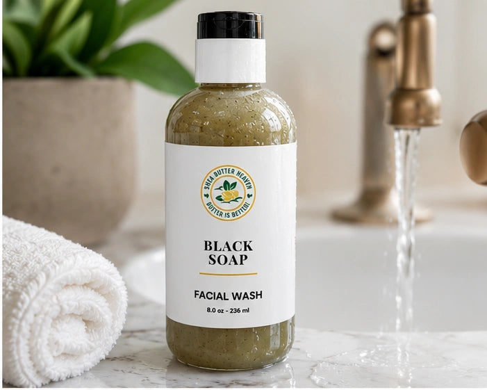 Shea Butter Heaven Black Soap Facial Wash in a clean bathroom setting with white towel and running water.